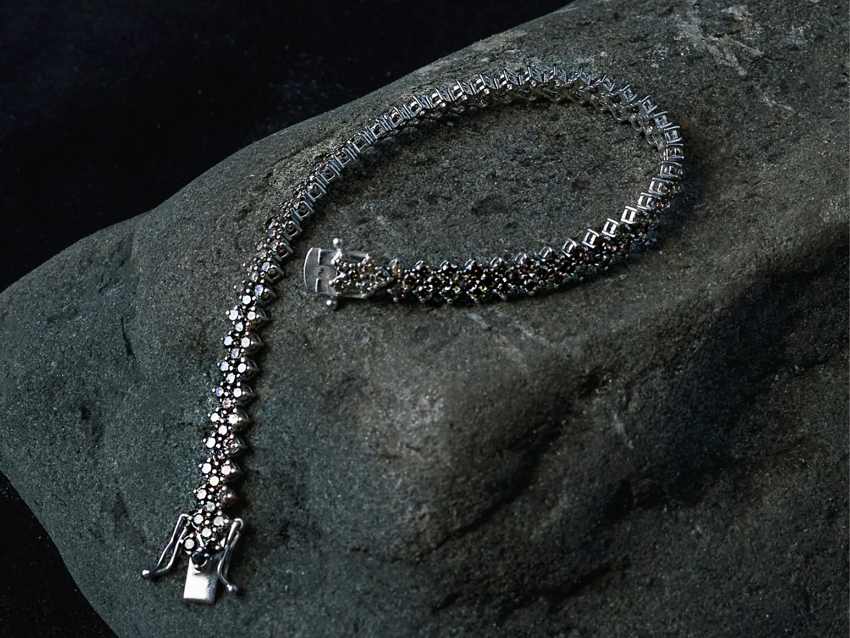 Bracciale tennis Celestial Bodies con pietre incastonate su roccia scura