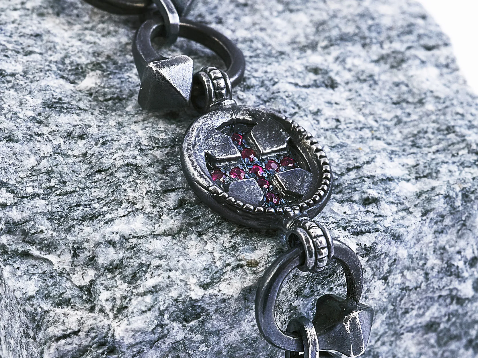 Bracciale Crossroads con croce incastonata di rubini su pietra grigia