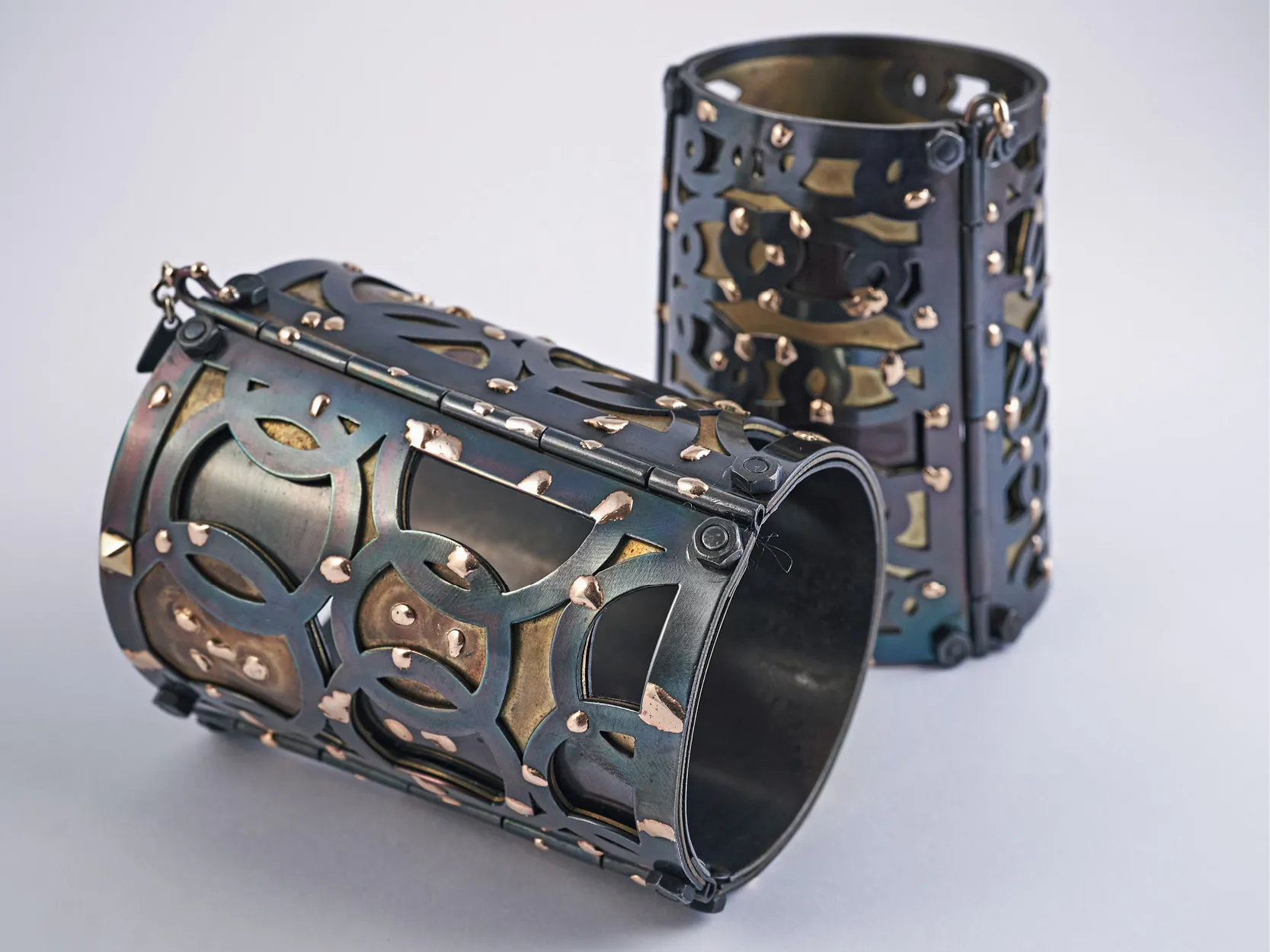 Due bracciali rigidi Tears of Gold in ferro brunito e oro 18 kt, lastre traforate a mano e imperniate